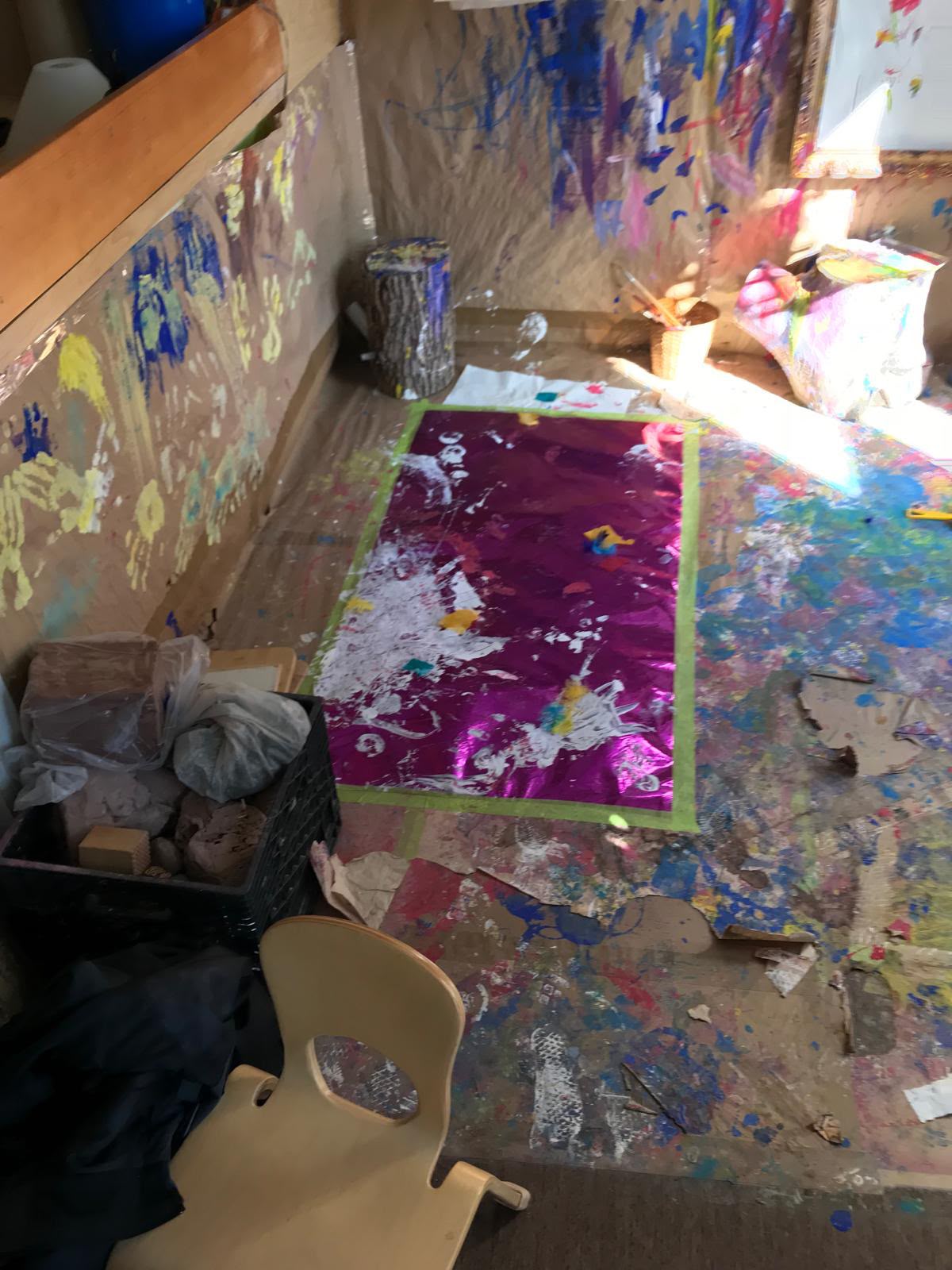 A paint-splattered creative play floor