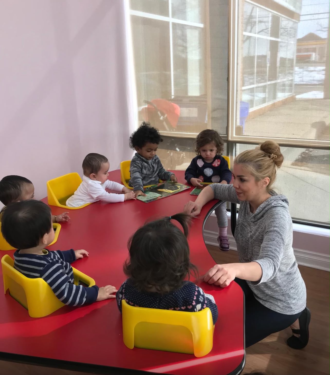 A group of toddlers reading together at a small table